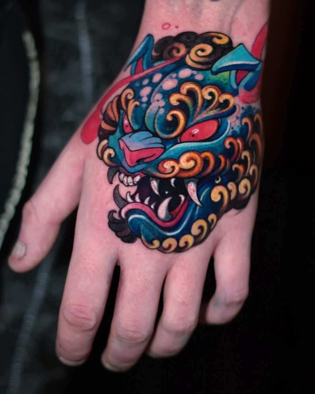 Japanse kleur tattoo van een foo hond op een hand