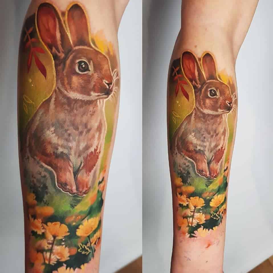 Tattoo van een konijn met bloemen in kleur realisme op onderarm. Geplaatst bij Inksane tattoo en piercing