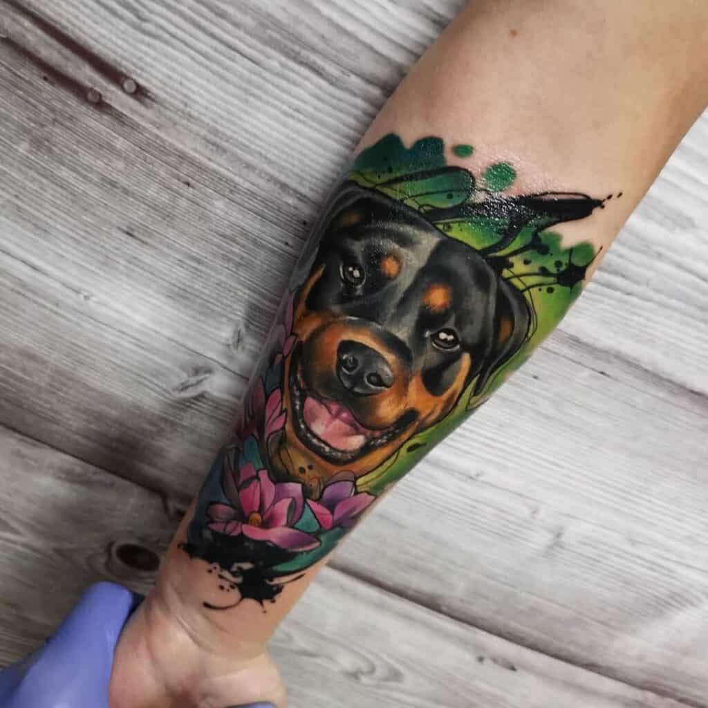New school kleurrijke tattoo op de binnenkant van een onderarm. Hond met bloemen en groene achtergrond.
