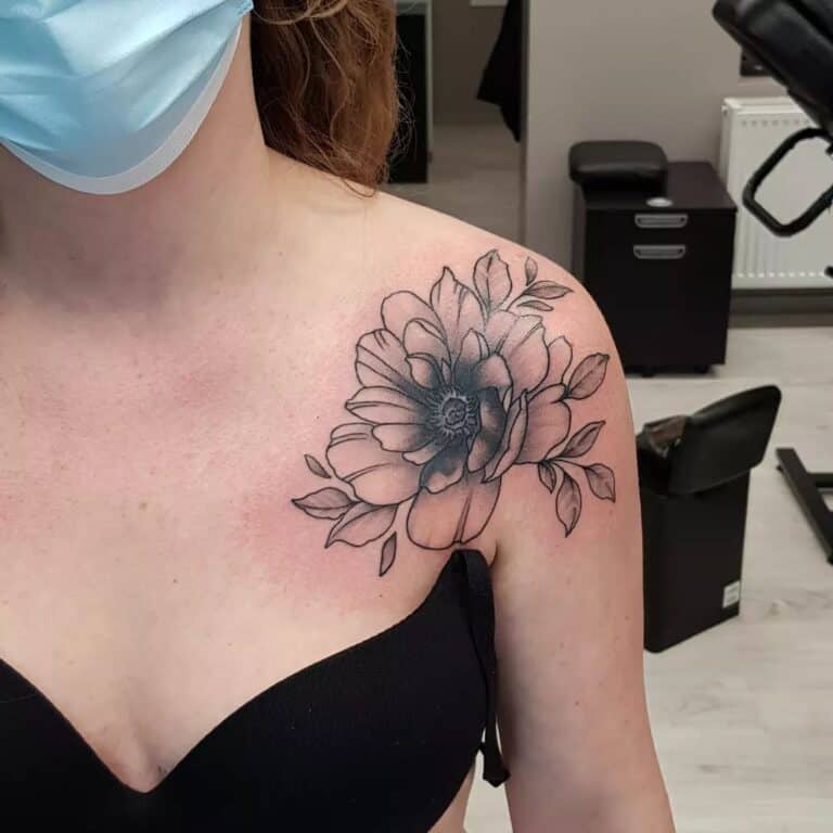 Black and grey bloem tattoo op schouder, gezet bij Inksane tattoo en piercing