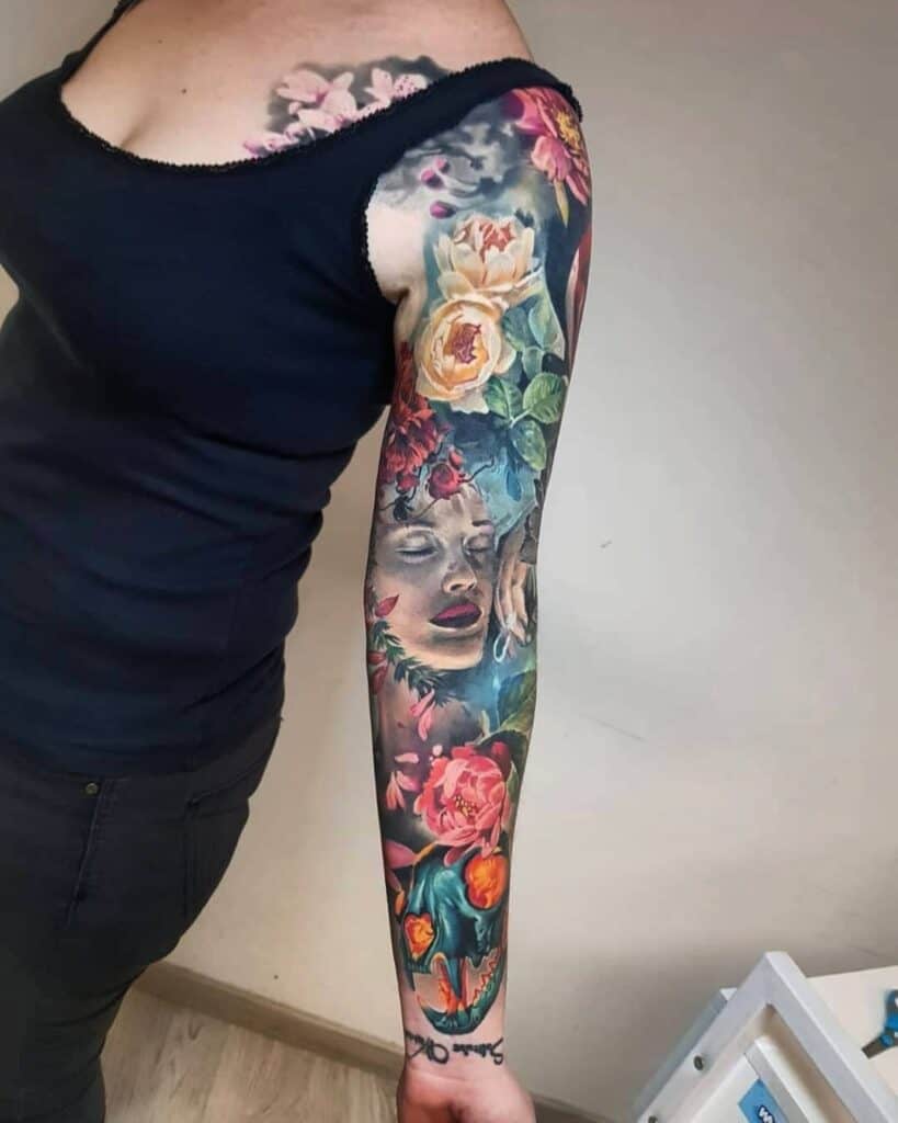 Een sleeve met vrouwengezicht en bloemen in kleur realisme op linkerarm. Geplaatst bij Inksane tattoo en piercing
