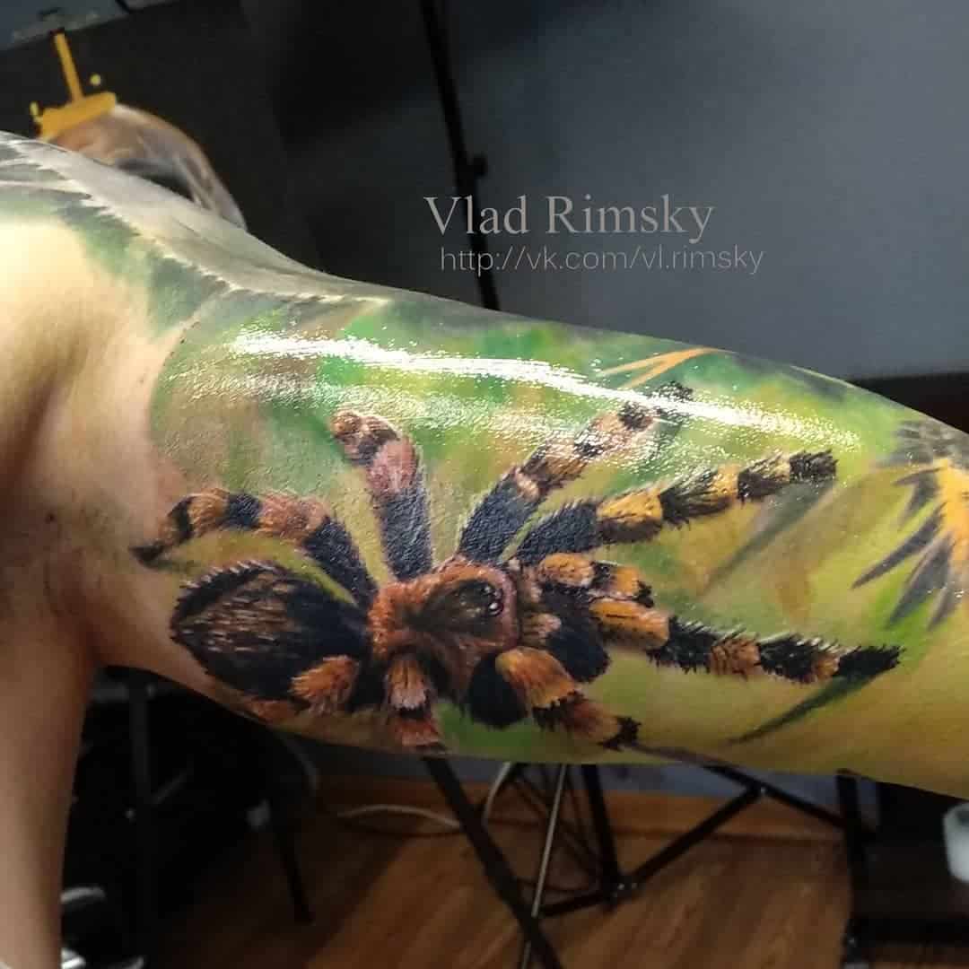 Kleur realisme tattoo van een tarantula op de binnenkant van een bovenarm.