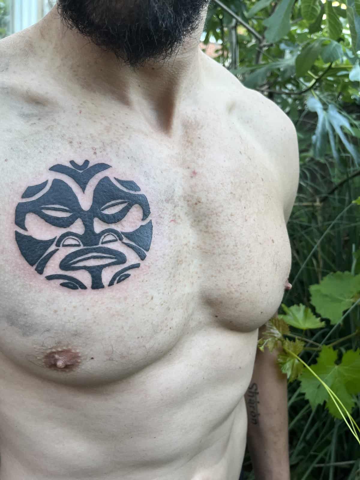Tattoo van een Maori gezicht op de borstkas