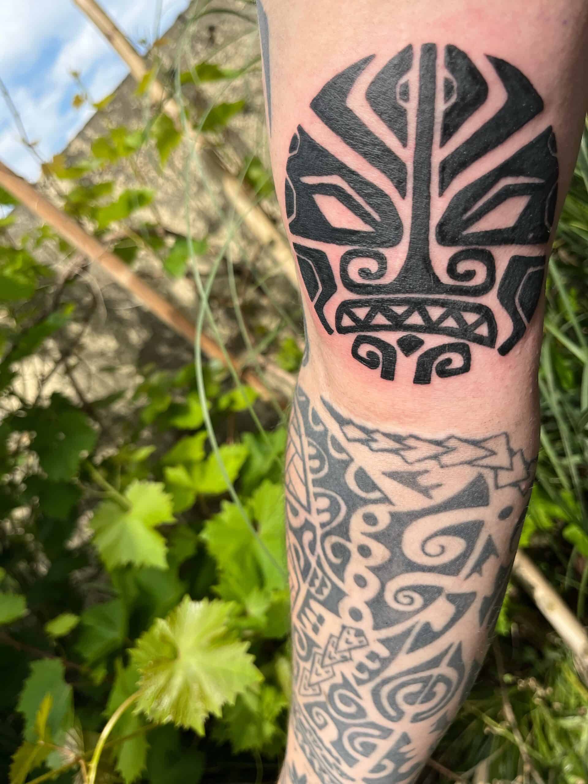 Maori stijl in de vorm van een gezicht, op de binnenkant van de bovenarm.