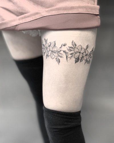 fine line flower tattoo on thigh